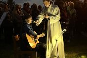 Berührende Lied mit Gitarre und Gesang. Ministranten hell erleuchtet hält Mikrofon